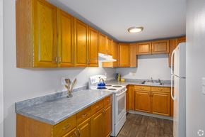 Somersworth apartment for rent - A kitchen with wooden cabinets and a white refrigerator.