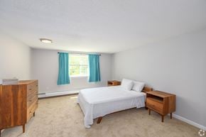 Somersworth apartment for rent - A bedroom with a bed, nightstand, and dresser.