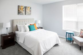 Quincy apartment for rent - a bedroom with a white bed and colorful pillows