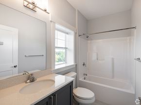 Nashua townhouse for rent - A white bathroom with a toilet, sink, and bathtub.