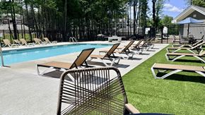 Swanzey apartment for rent - A poolside area with chairs and a table.