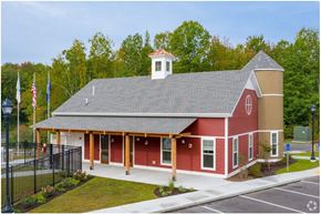 Somersworth apartment for rent - A red building with a white steeple and a black fence in front.