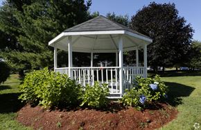 Somersworth apartment for rent - A white gazebo with a black roof is surrounded by green plants and trees.