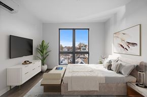 Beverly apartment for rent - A bedroom with a large bed, a flat screen TV, and a window with a view of the city.