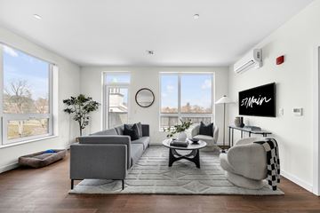 Marlborough apartment for rent - A modern living room with a grey sofa and a black and white checkered chair.