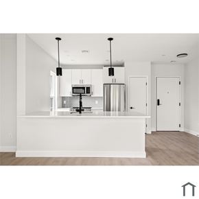 Lynn apartment for rent - A modern kitchen with a white island and pendant lights.
