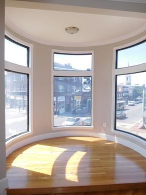 Brighton apartment for rent - A sunny day in a room with a curved ceiling and three large windows.