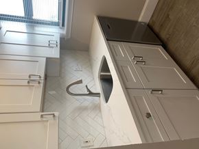 Brighton apartment for rent - A modern bathroom with a white tiled floor and a large sink.