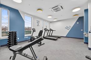 Washington apartment for rent - A gym with a row of treadmills and a weight rack.