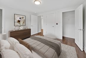 Washington apartment for rent - A bedroom with a bed, dresser, and a painting on the wall.