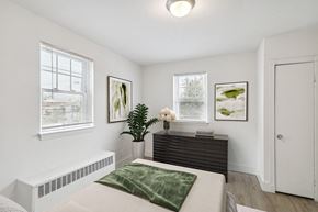 Baltimore apartment for rent - a bedroom with a bed and a dresser and two windows