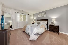 Columbia apartment for rent - A bedroom with a large bed and a nightstand with a lamp.