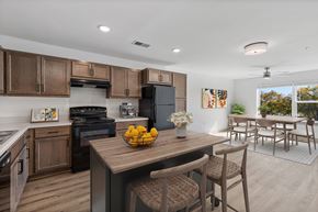 Raleigh apartment for rent - A kitchen with wooden cabinets and a black refrigerator.
