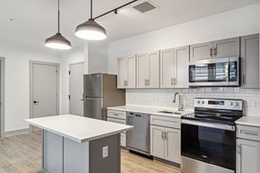 Baltimore apartment for rent - a kitchen with stainless steel appliances and white cabinets