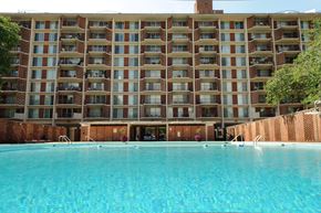 Washington apartment for rent - A large building with a pool in front of it.