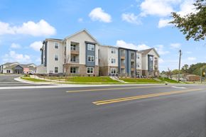 Durham apartment for rent - Apartment building on a street corner with a clear blue sky.