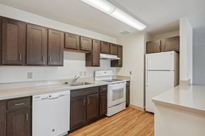 Alexandria apartment for rent - A kitchen with white appliances and brown cabinets.