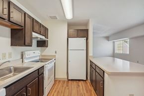 Alexandria apartment for rent - A kitchen with white appliances and wooden cabinets.