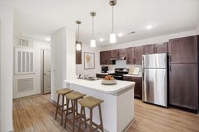 Apex apartment for rent - A kitchen with a white island and brown bar stools.