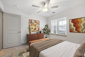Apex apartment for rent - A bedroom with a bed, dresser, and a ceiling fan.