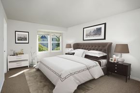 Jessup apartment for rent - A bedroom with a large bed and a window overlooking a blue house.