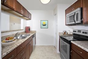 Jessup apartment for rent - A kitchen with brown cabinets and a white fridge.