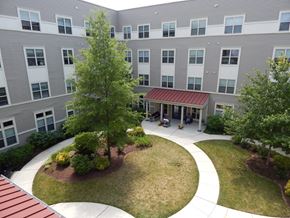 Washington apartment for rent - A courtyard with a tree and a building in the background.
