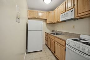 Kensington apartment for rent - a kitchen with white appliances and wooden cabinets