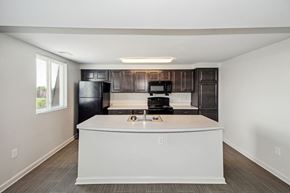Baltimore apartment for rent - an empty kitchen with a counter top and a refrigerator