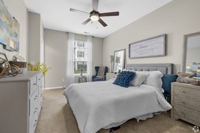 Ofallon apartment for rent - A bedroom with a large bed and a ceiling fan.