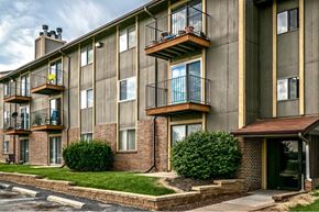 Omaha apartment for rent - a brick apartment building with balconies and green grass