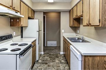 Omaha apartment for rent - a kitchen with white appliances and wooden cabinets