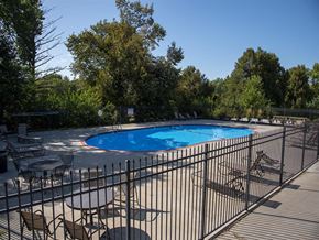 Omaha apartment for rent - a swimming pool with chairs and tables next to a fence