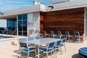 Clayton apartment for rent - A poolside table with chairs and a warning sign on the wall at Two Twelve Clayton Apartments, Missouri