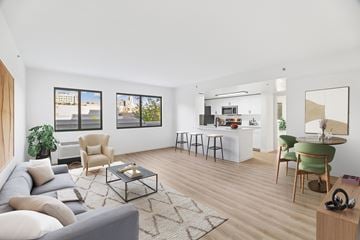 Philadelphia apartment for rent - A living room with a grey couch, a coffee table, and a dining table with chairs.