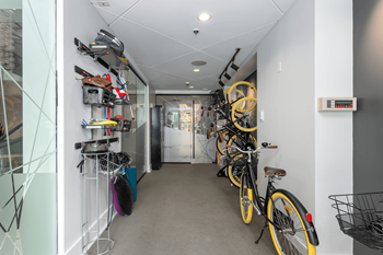 A hallway with bicycles on the right and a bike rack on the left.