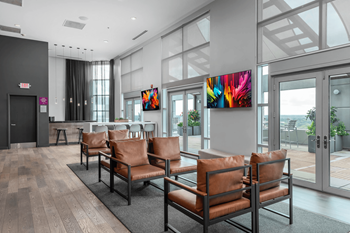 A waiting area with brown leather chairs and a large painting on the wall.