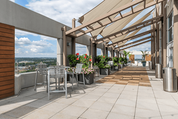 A patio with a table and chairs under a roof.