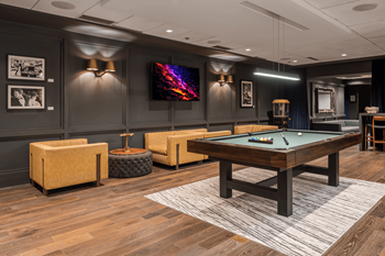 A room with a pool table and a television.