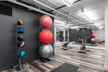 A gym with a variety of exercise balls and equipment.