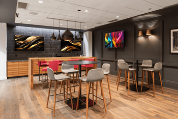 A modern dining room with a wooden table and chairs.