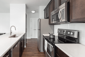 Clayton apartment for rent - A modern kitchen with dark wood cabinets and stainless steel appliances at Clayton on the Park Apartments, Clayton, MO