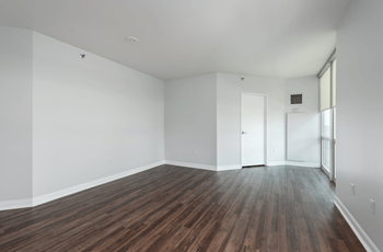 A room with wooden flooring and white walls.