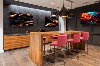 A modern kitchen with a wooden island and red chairs.
