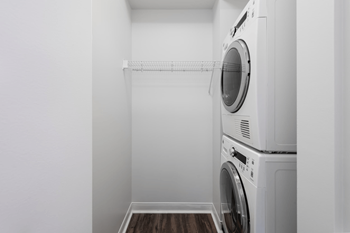 A white laundry room with a washer and dryer stacked on top of each other.