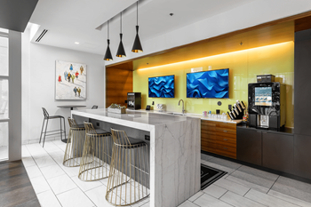 A modern kitchen with a bar area and a painting on the wall.