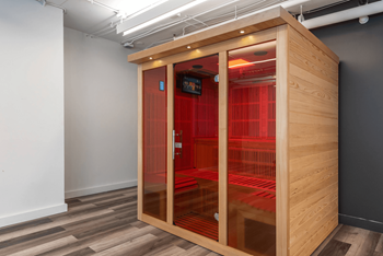 A wooden pod with red dividers in a room with grey walls.