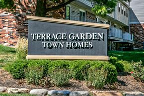 Omaha apartment for rent - a sign for the terrace garden town homes in front of a building