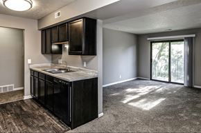 Omaha apartment for rent - an empty living room with a kitchen and a sliding glass door