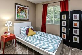 Omaha apartment for rent - a bedroom with a bed with a blue and white bedspread and a red table